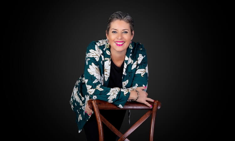 A person with short hair wearing a floral jacket.
