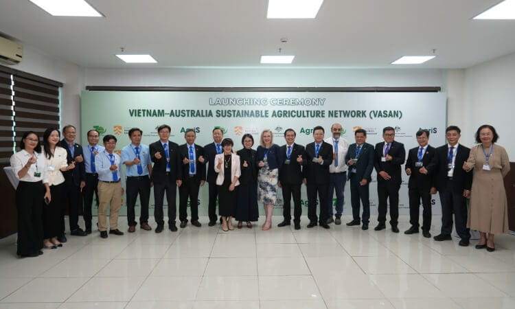 A group of people stand in a row, posing for a photo at the Vietnam-Australia Sustainable Agriculture Network launching ceremony in a bright indoor setting.