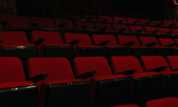 Rows of empty red theater seats.