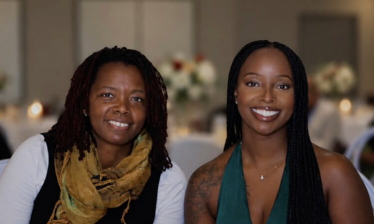 Two women smiling side-by-side.