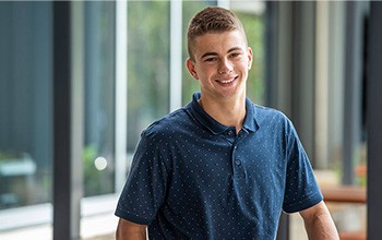 Ethan standing outside, smiling at the camera.