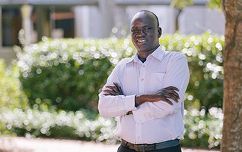 Elijah is standing outside, smiling at the camera.