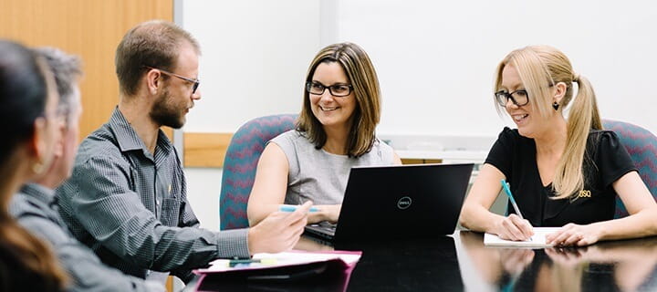 A group of people interacting at a conference table.