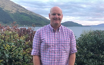 UniSQ Alumni standing with mountainous views in background
