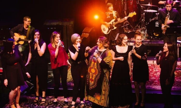 a band on a stage with singers in front