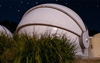 Observatory dome under a starlit night sky.