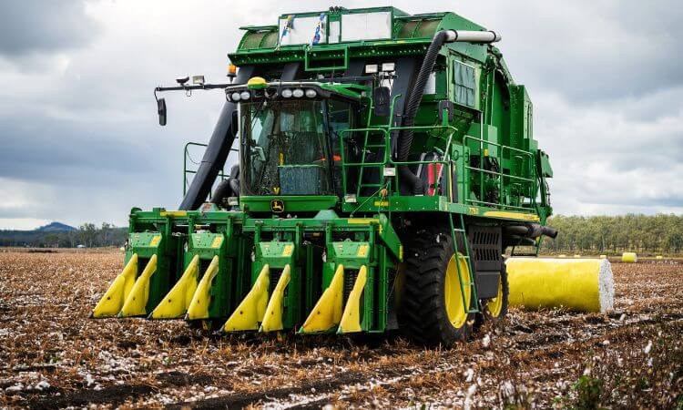 a havester bailing cotton a field