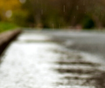 Raindrops on a blurred street scene.