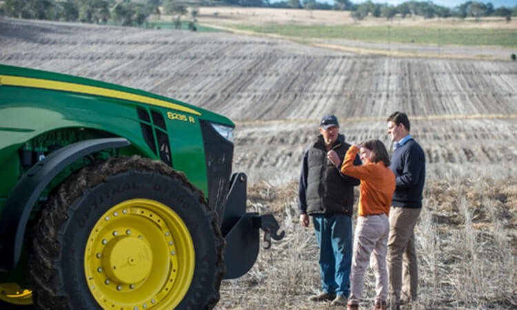 People in paddock with tractor. 