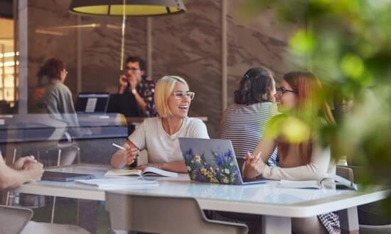 Colleagues engaged in a discussion at a modern office meeting space.