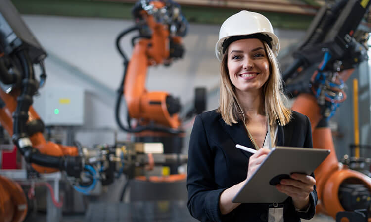 A lady with a checklist standing in front of industrial equipment. 