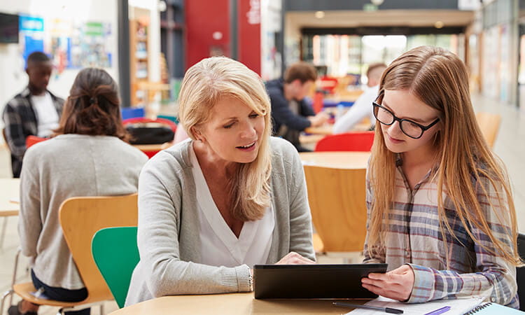 A professional lady talking to a high school student.