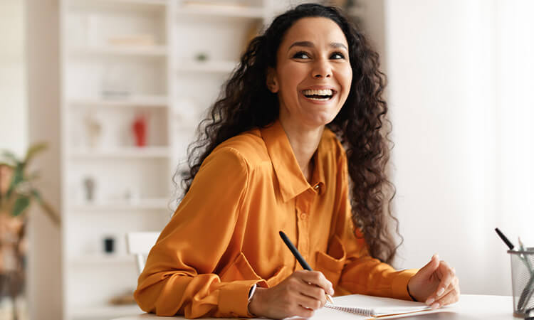 Lady sitting at a desk writing.