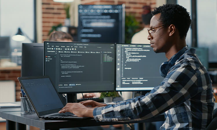 Man working on coding at a computer. 