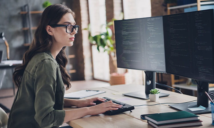 Lady working on code at computer.