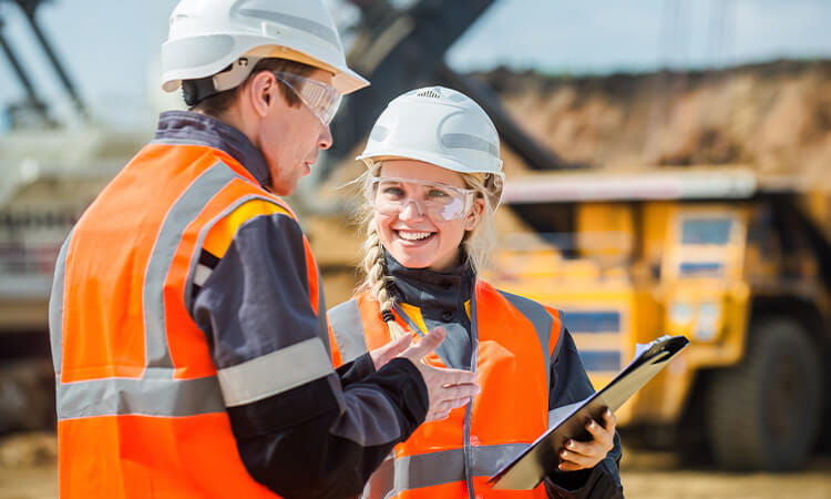 Two people talking on a mine site.