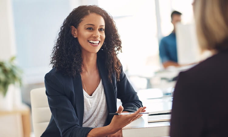 Lady talking to another person out of shot in an office environment. 