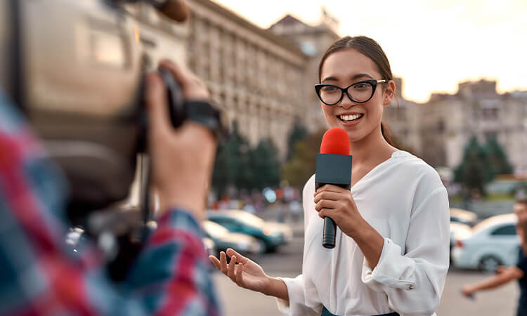 Journalist talking to camera while outside.