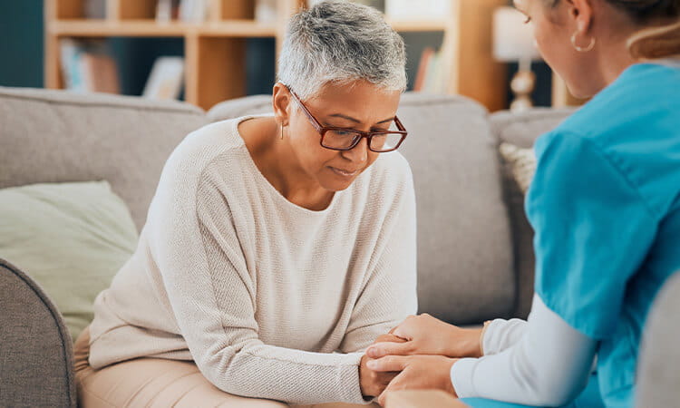 Nurse talking to client who looks emotional.