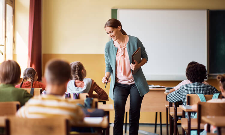 Teacher in a classroom of children. 