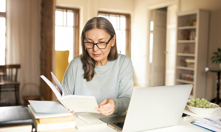 A woman intently looking over some written documents. 