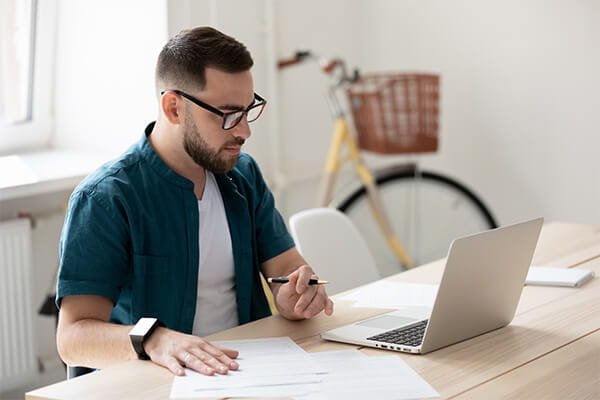 Student sitting at desk working on laptop. 