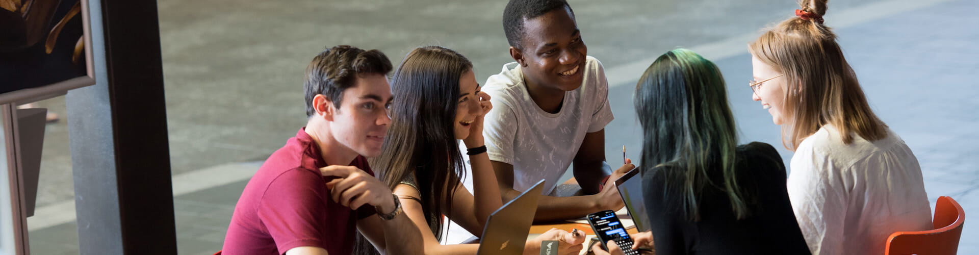 A group of young adults engaged in a lively conversation around a table.