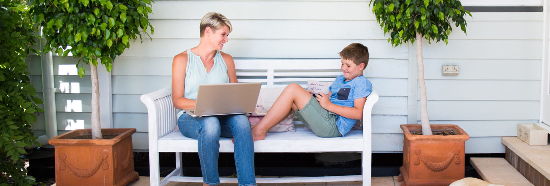 Mother with laptop studying at home with her son.