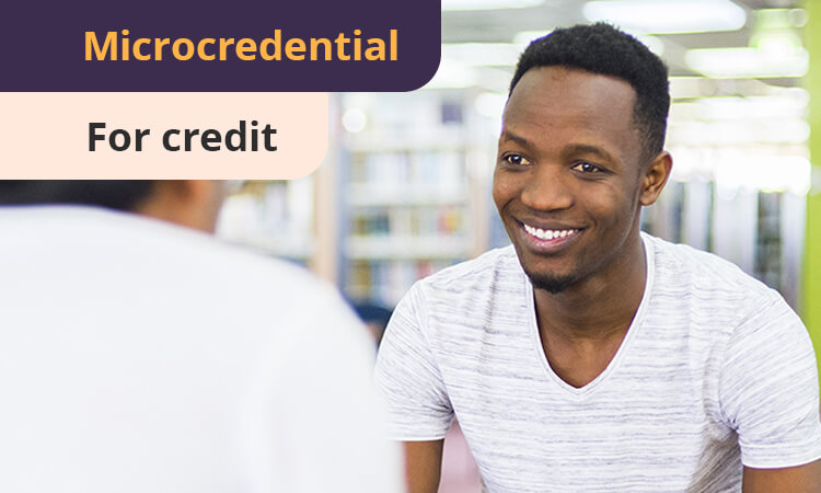 Smiling person in a white shirt sits facing another individual, with text reading "Microcredential For credit" in the background.