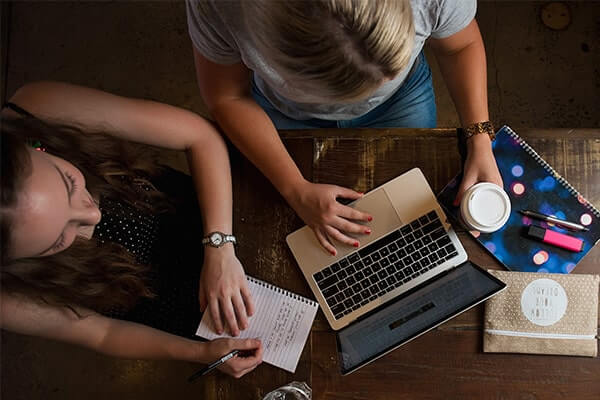 Above view of two females studying at cafe