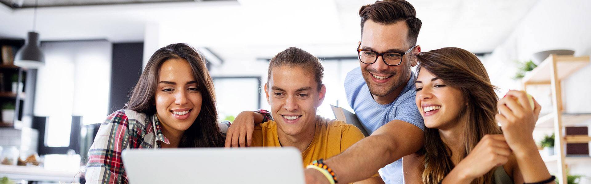 Group of students looking at laptop.