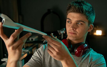 Aerospace engineering student inspecting spacecraft model