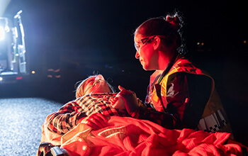 Paramedic student helping patient on stretcher