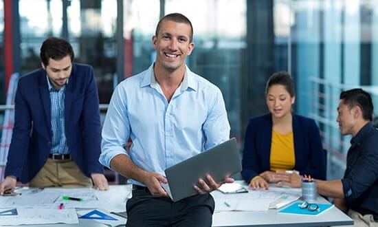 A group of professional staff sitting around a desk.