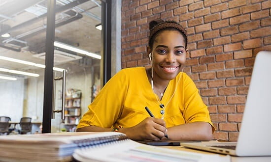 Student appearing to be studying at desk with pen in hand.