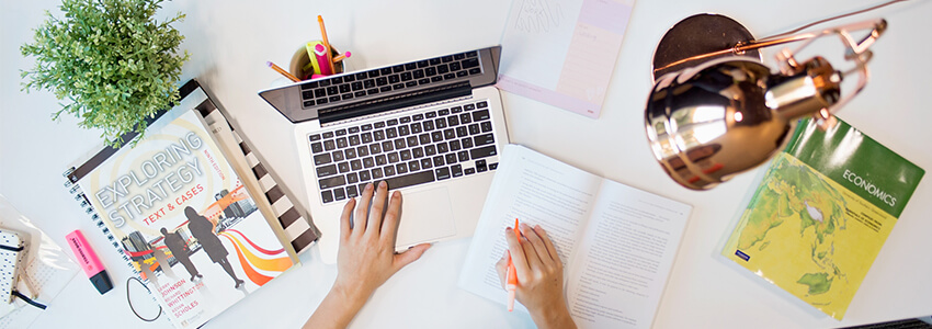 Overhead view of organised study desk with laptop and study materials