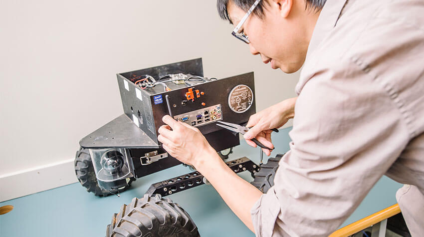 Technician repairing electronic components of a robotic device.