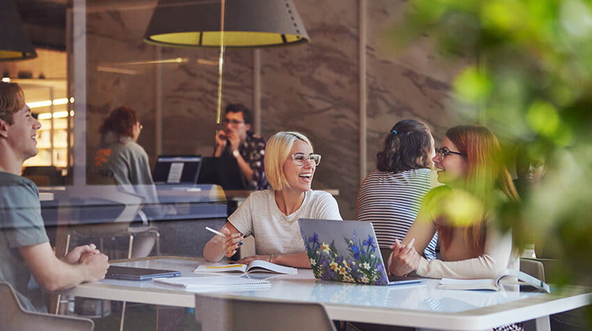 A group of people sitting at a table in an office.