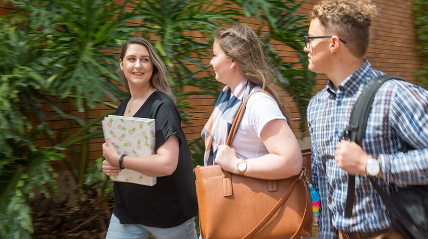 A group of students walking down a street.