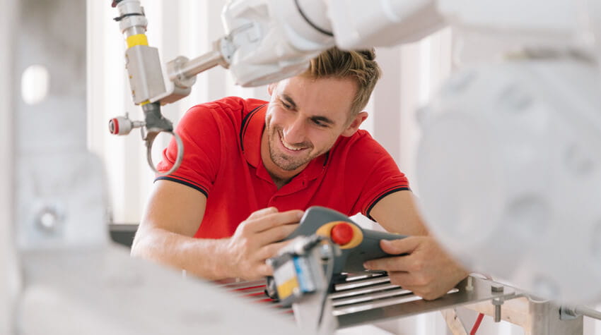 Fraser is smiling while using robotic equipment.